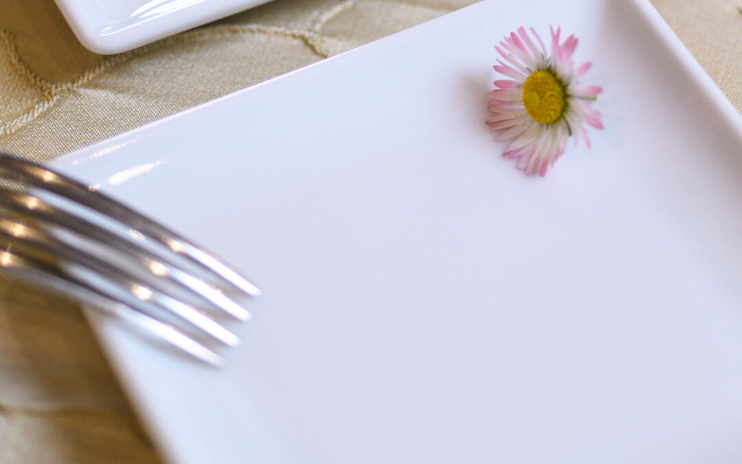 Piatto vuoto con fiore decorativo per impiattamento creativo nella cucina del ristorante a Coassolo vicino Torino
